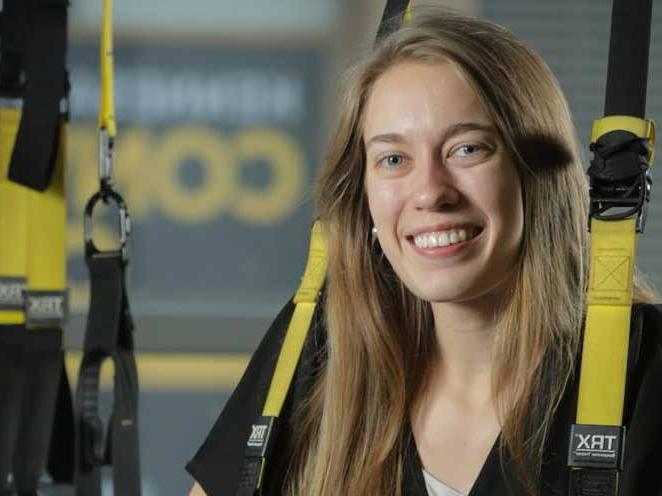 Woman strapped into safety gear smiling for a picture