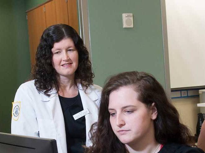 Teacher watching student focus on the computer